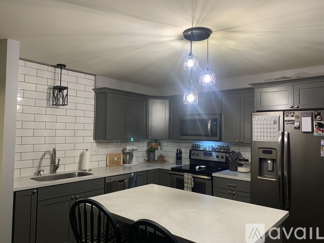 A kitchen with a white table and black chairs.