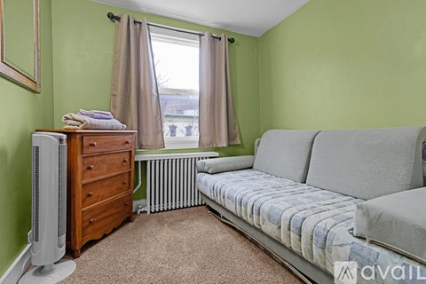 A living room with a grey sofa and a wooden dresser.