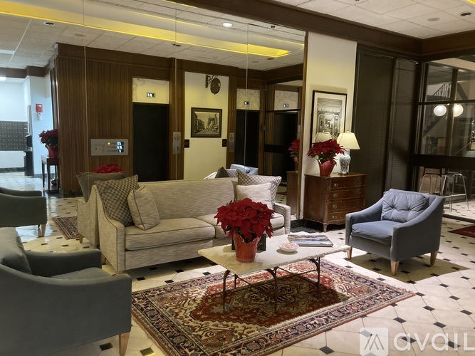 A living room with a couch, chairs, and a rug.
