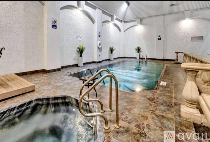 A large indoor swimming pool with a slide and a bench.