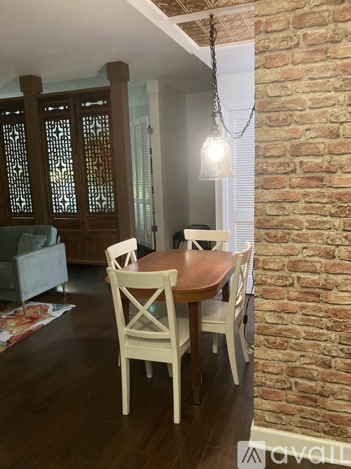 A dining room with a wooden table and chairs.