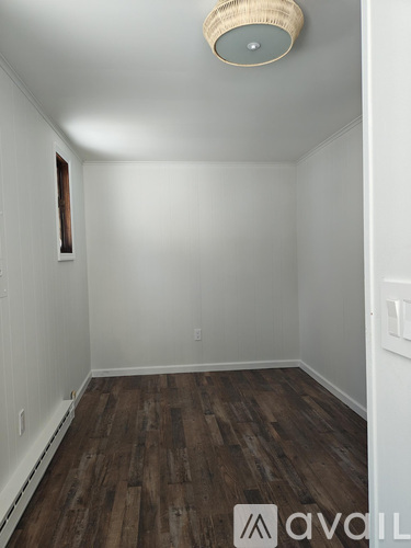 A room with wooden floors and white walls.