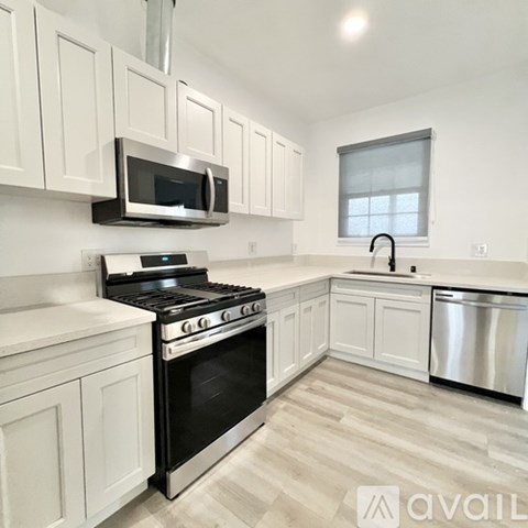 A kitchen with white cabinets and stainless steel appliances.