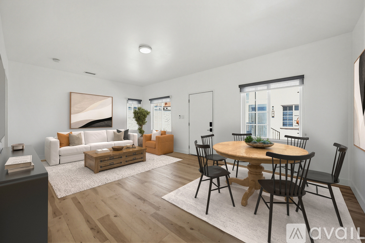 A living room with a white couch, a wooden coffee table, and a ceiling fan.