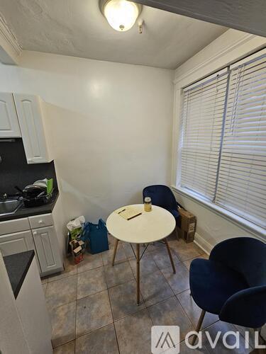 A kitchen with a table and chairs in front of a window.