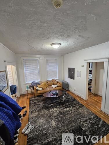 A living room with a couch, a coffee table, and a rug.