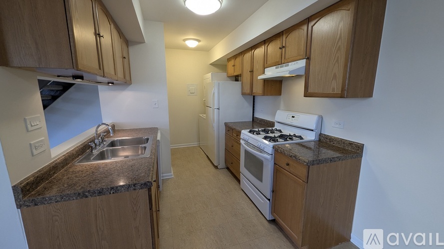A kitchen with wooden cabinets and a granite countertop.