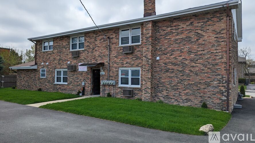 A brick building with a white door and windows.