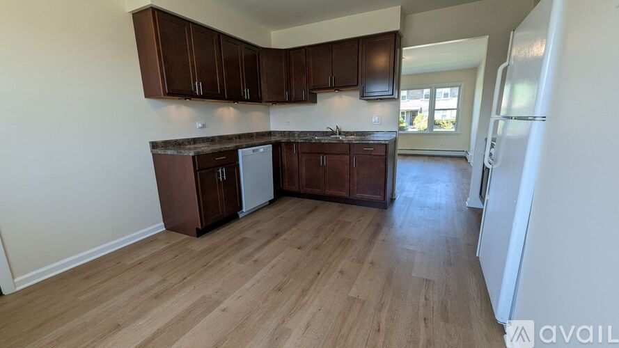 A kitchen with brown cabinets and a refrigerator.