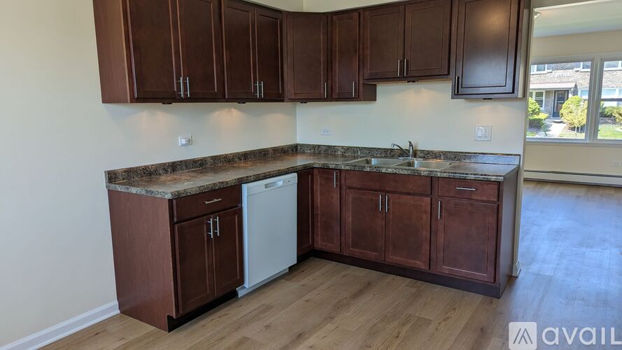 A kitchen with brown cabinets and a marble countertop.