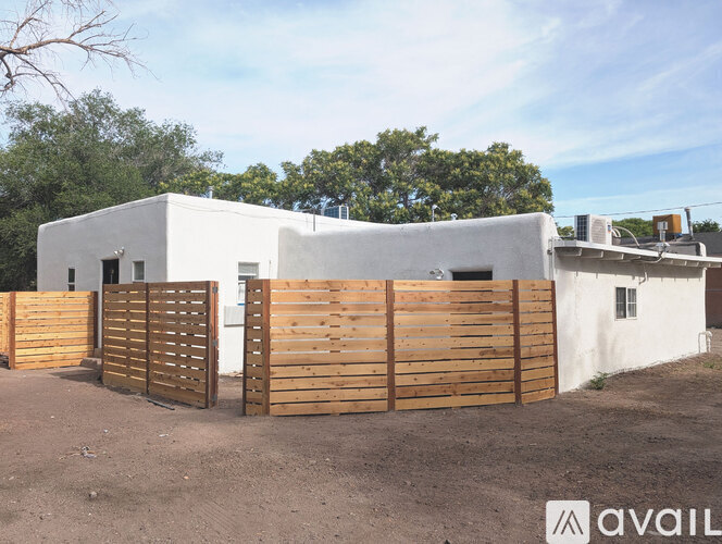 A white house with a wooden fence in front of it.