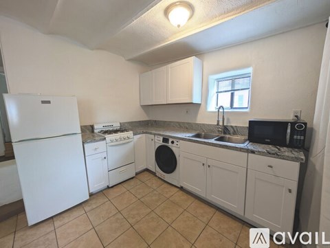 A kitchen with white appliances and cabinets.
