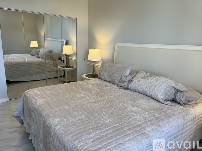 A bedroom with a large bed and a mirror on the wall.