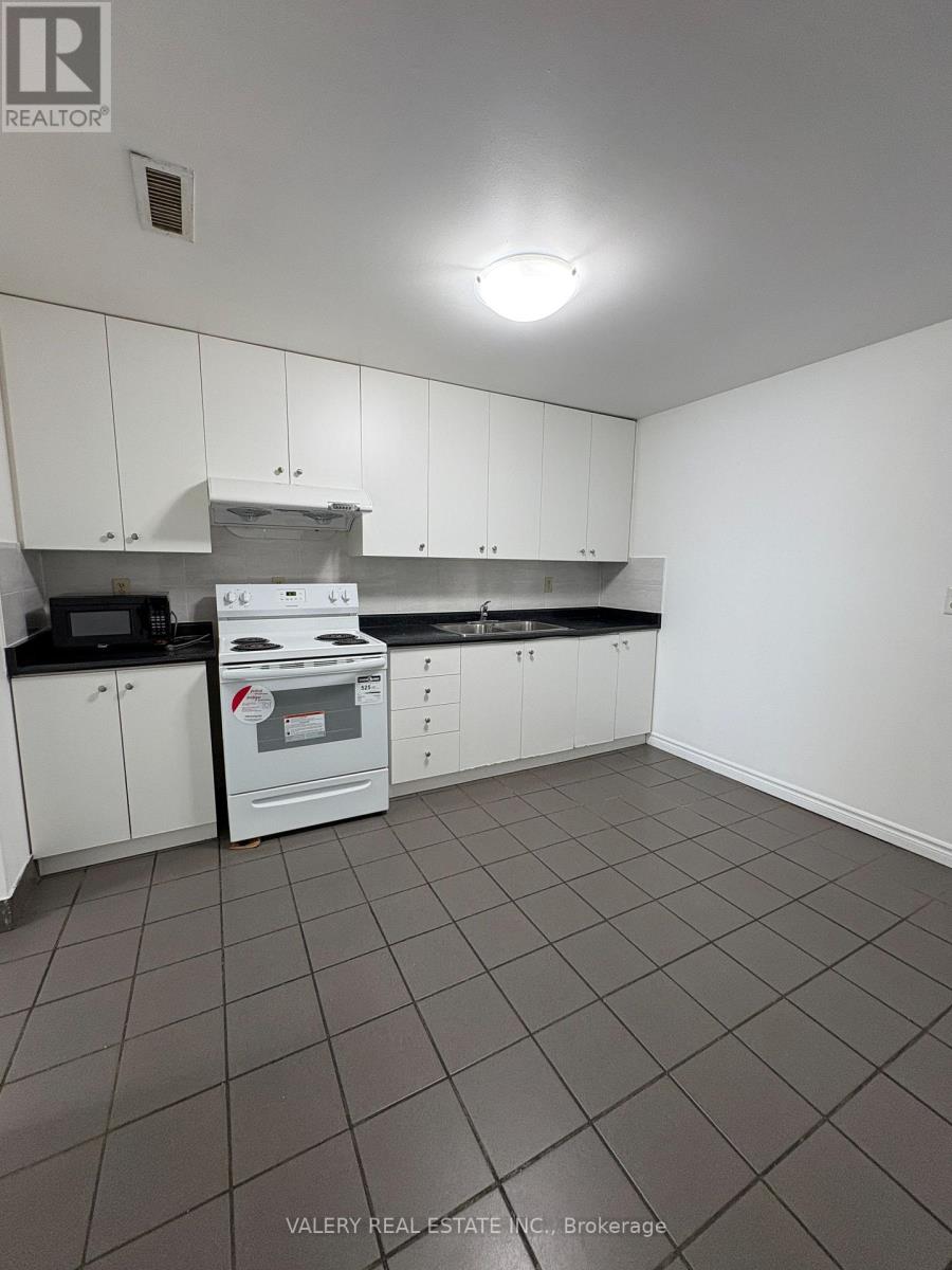 A kitchen with white cabinets and a black counter top.
