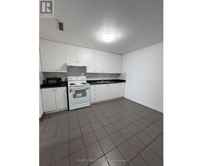 A kitchen with white cabinets and a black counter top.