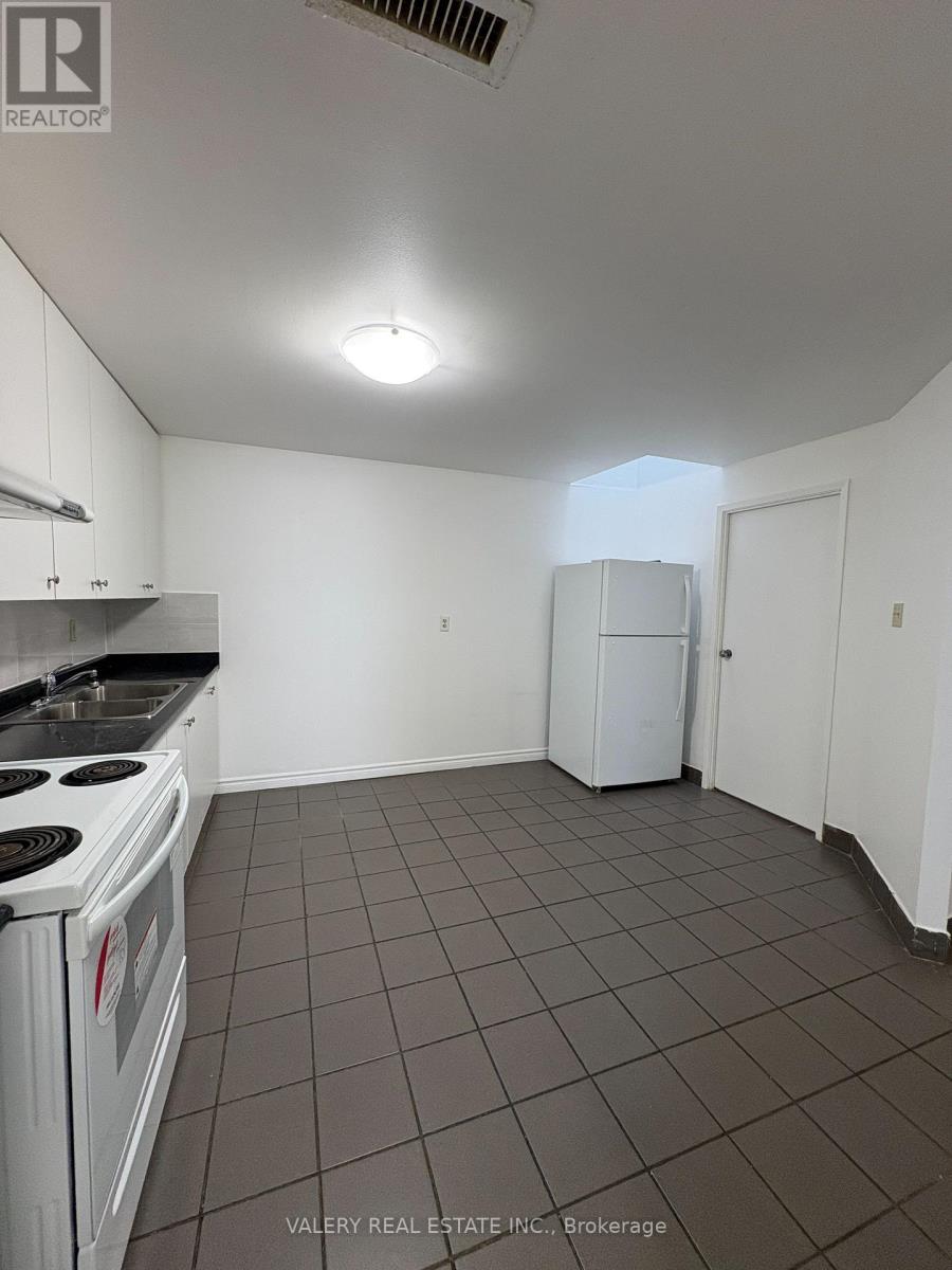 A kitchen with white cabinets and a white stove top oven.