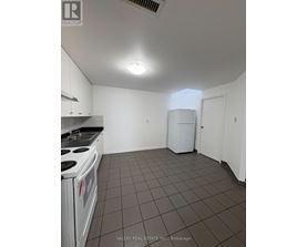 A kitchen with white cabinets and a white stove top oven.