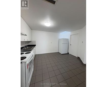 A kitchen with white cabinets and a white stove top oven.