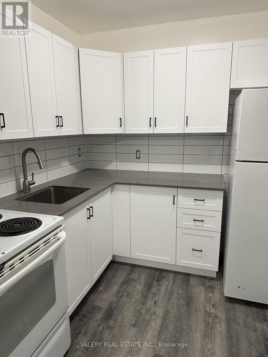 A kitchen with a stove top oven and a refrigerator.