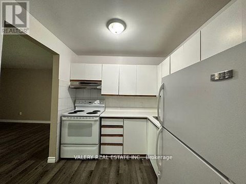 A kitchen with white cabinets and a stove top oven.