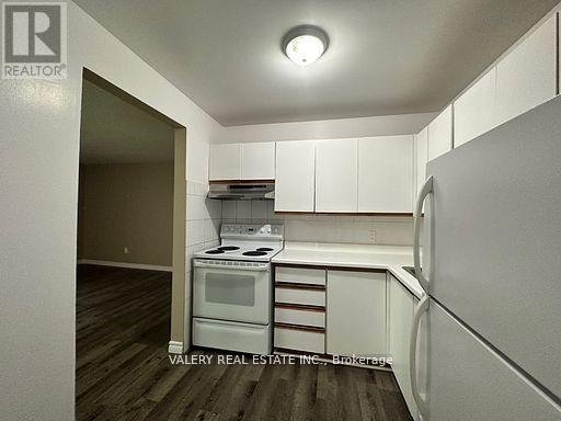 A kitchen with a stove top oven and a refrigerator.