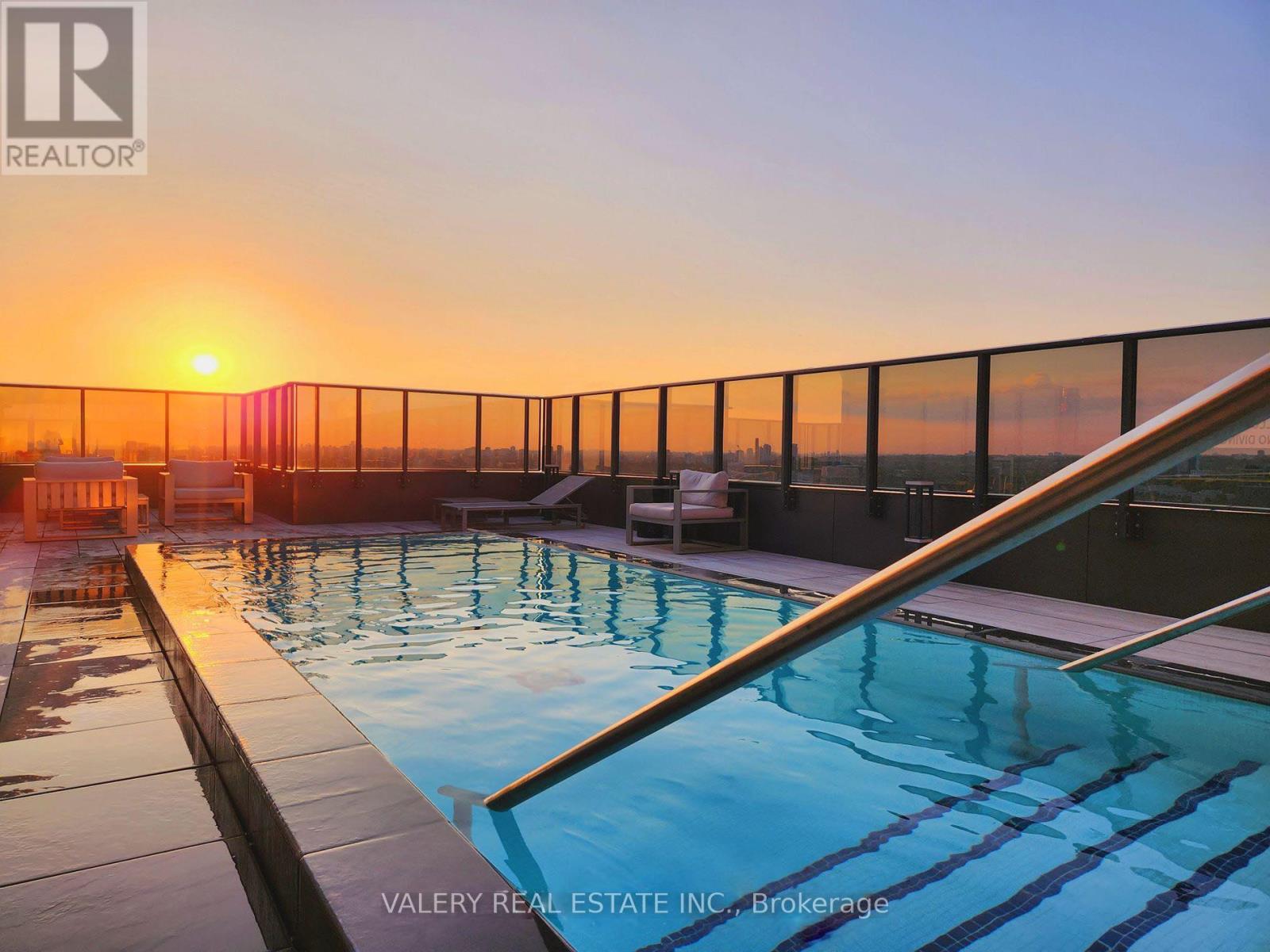 A pool with a sunset in the background.
