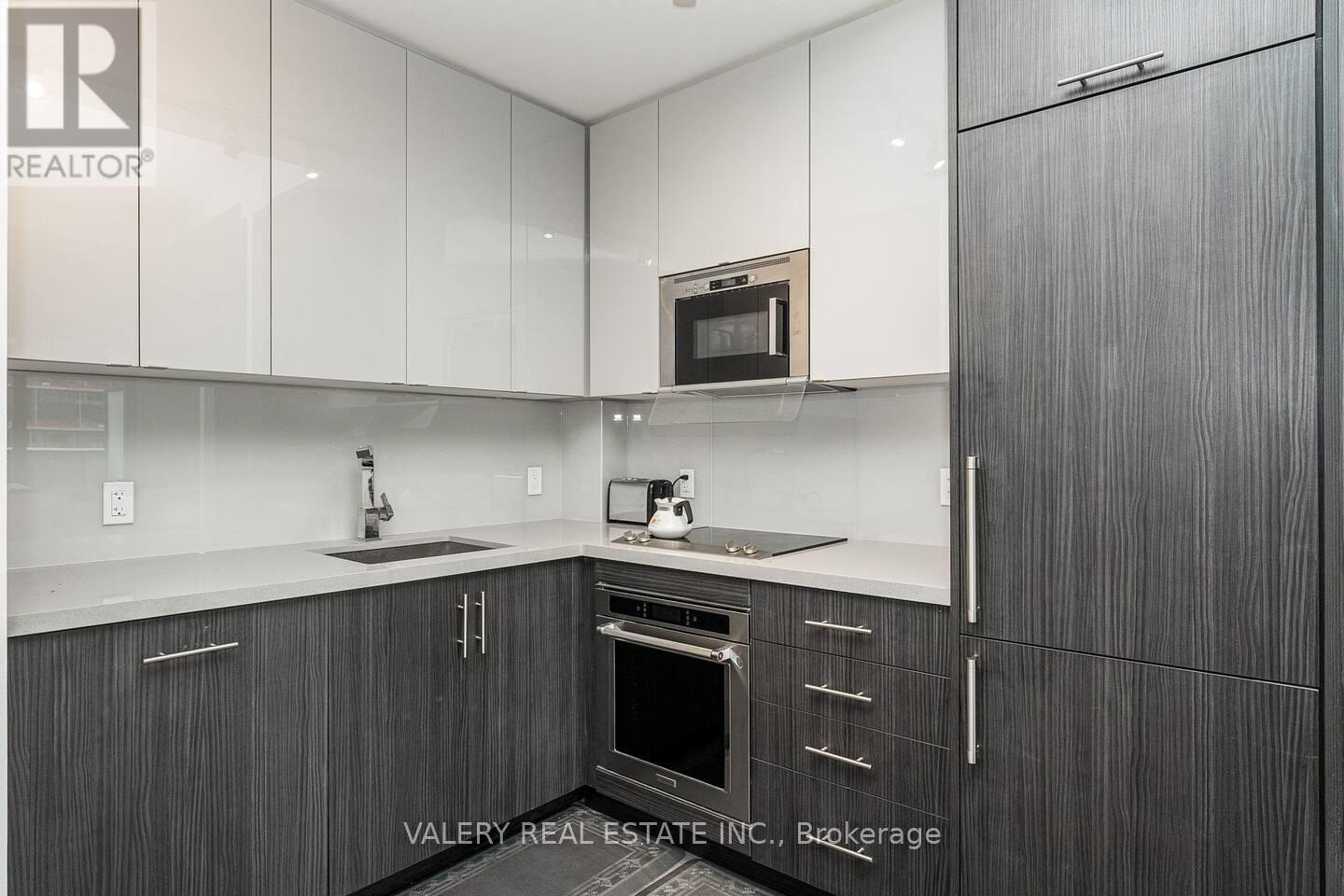 A modern kitchen with dark wood cabinets and white countertops.