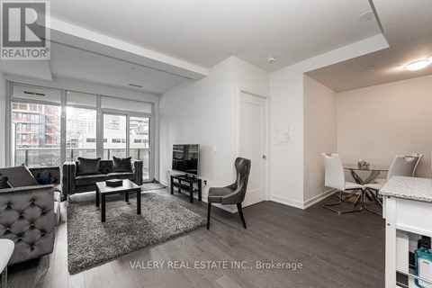 A living room with a black chair and a white couch.