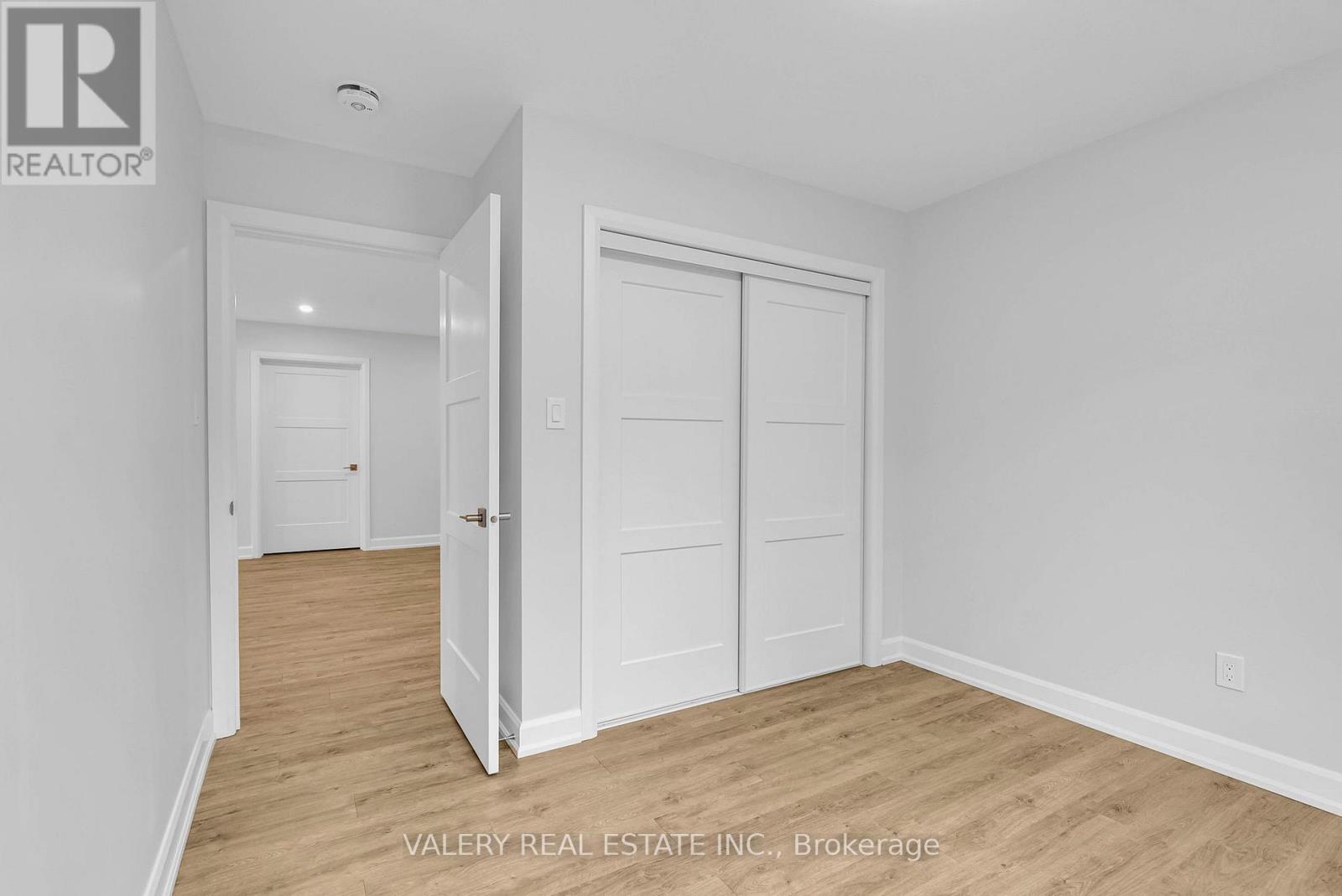 A white bedroom with a door and a window.