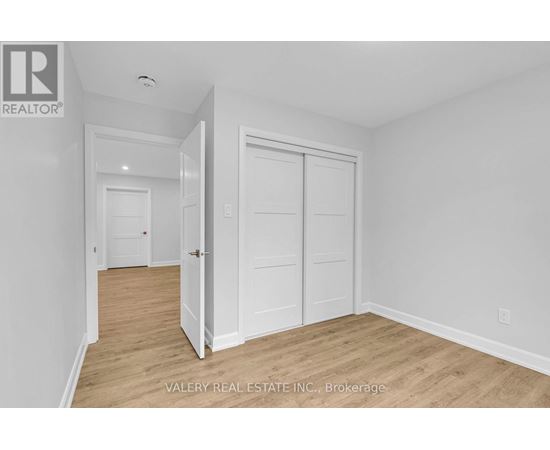 A white bedroom with a door and a window.