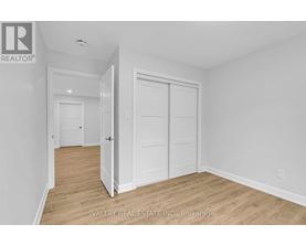 A white bedroom with a door and a window.