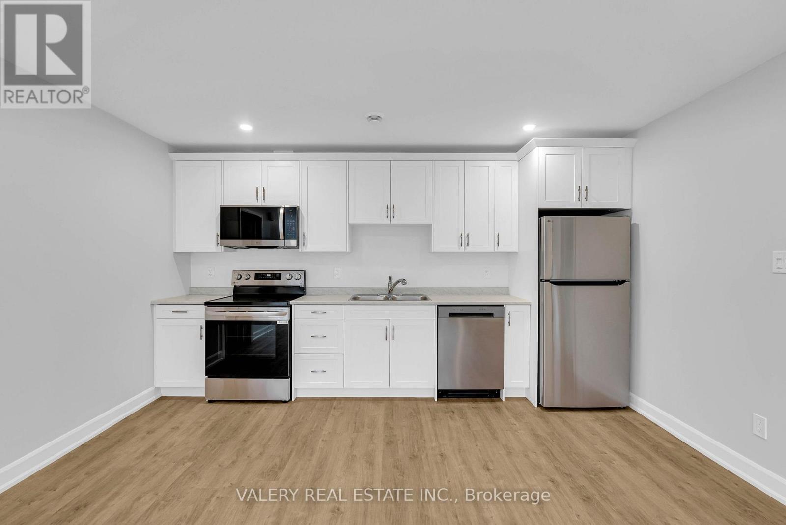 A kitchen with white cabinets and stainless steel appliances.