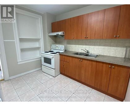 A kitchen with white appliances and wooden cabinets.
