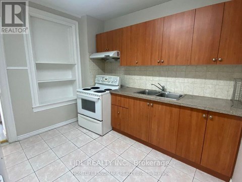 A kitchen with white appliances and wooden cabinets.