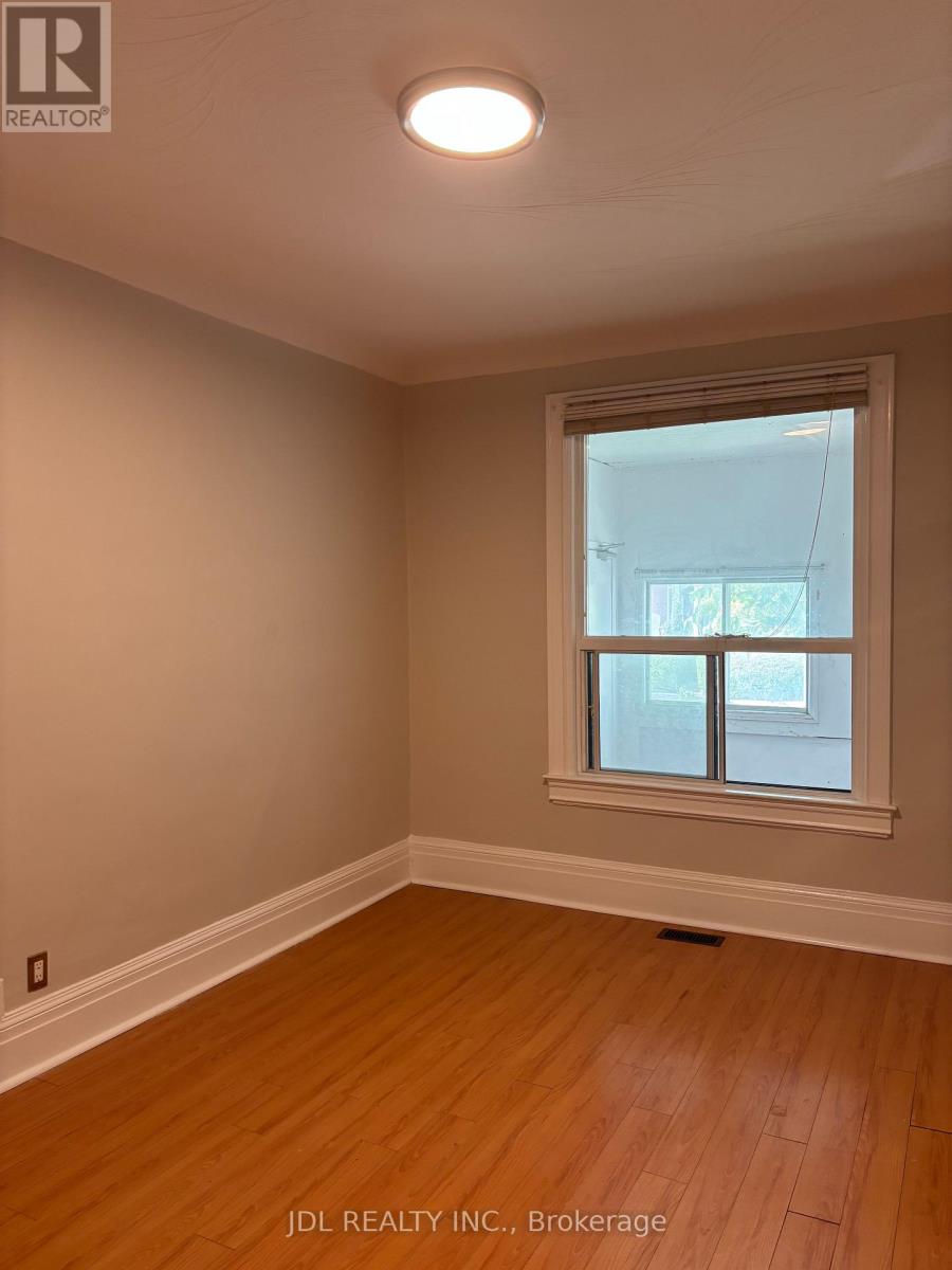 A room with a window and wooden flooring.