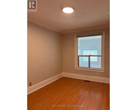 A room with a window and wooden flooring.
