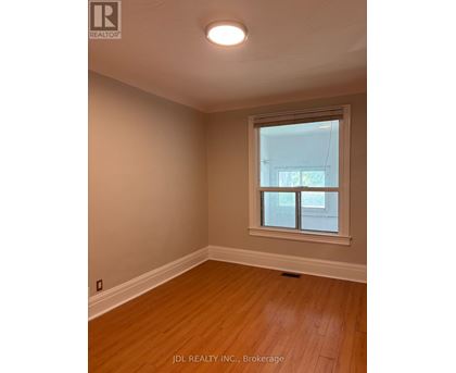 A room with a window and wooden flooring.