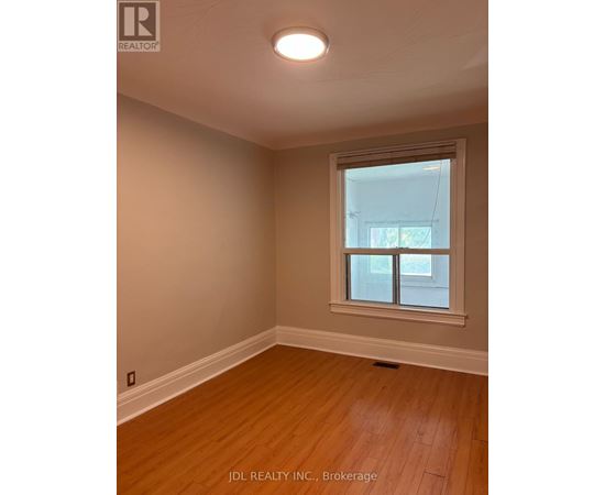 A room with a window and wooden flooring.