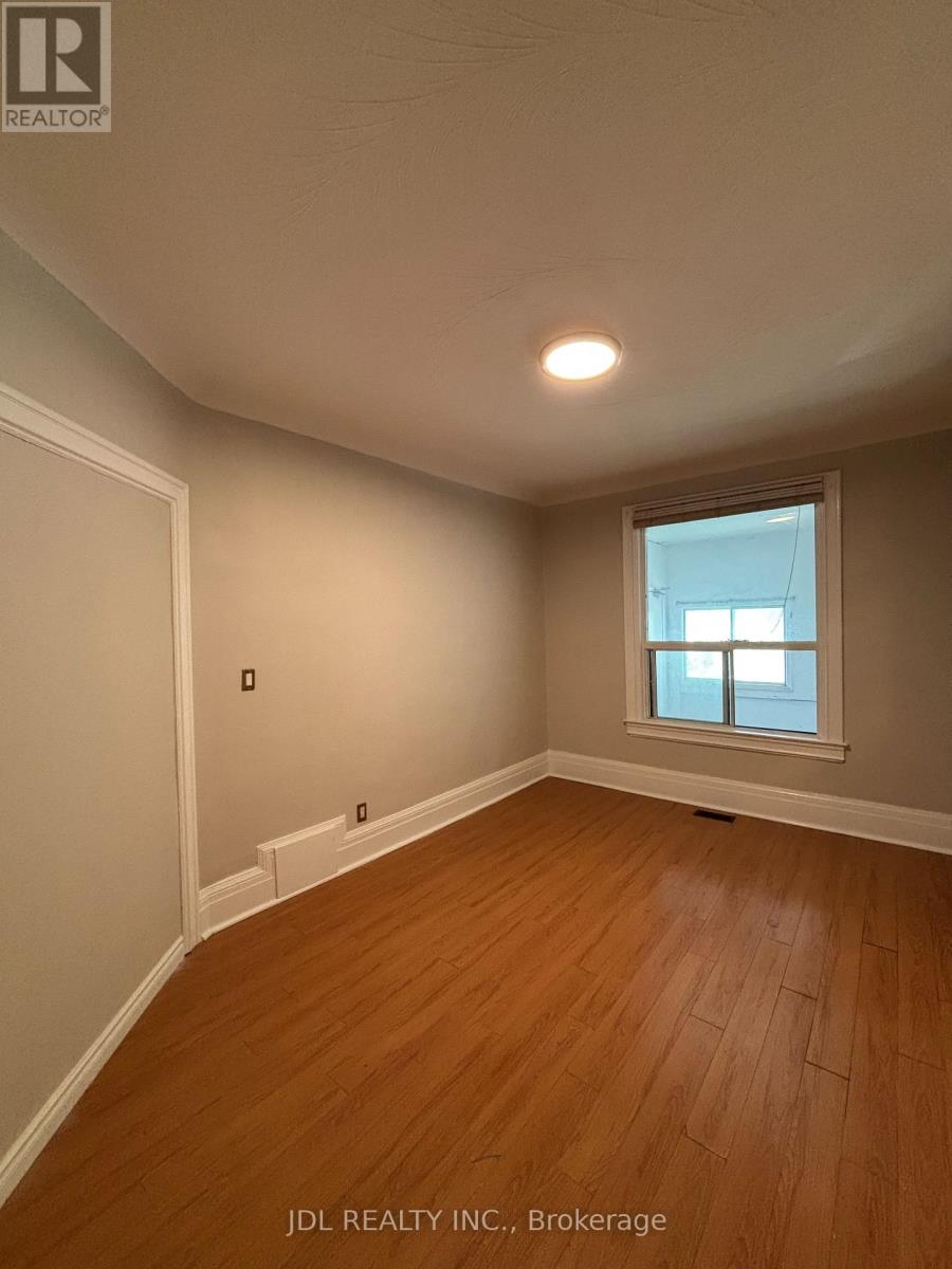 A room with wooden flooring and a window.