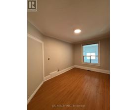 A room with wooden flooring and a window.
