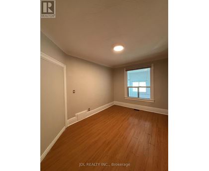 A room with wooden flooring and a window.