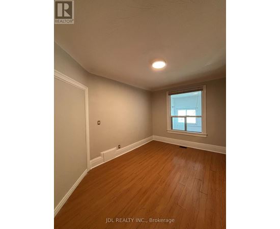A room with wooden flooring and a window.