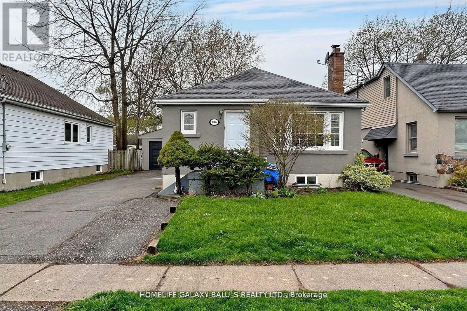 A house with a grey roof and a white garage door is for sale.