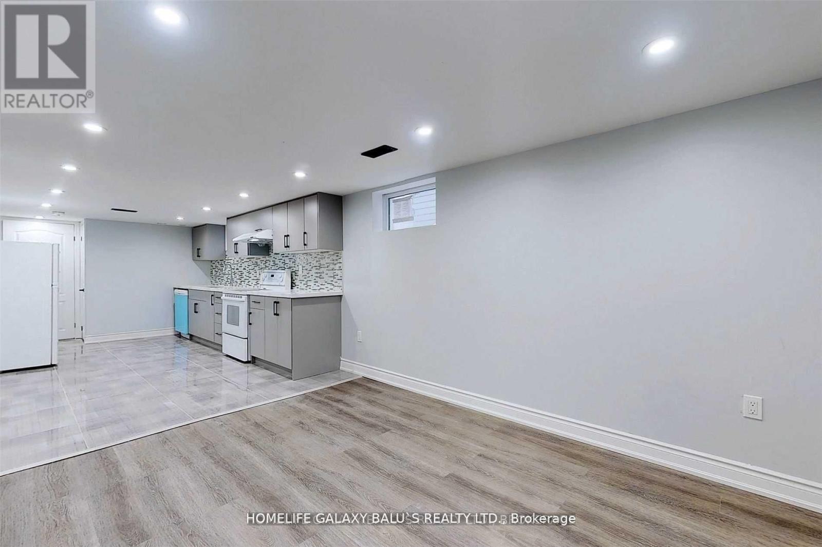A room with a kitchenette and a refrigerator in it.