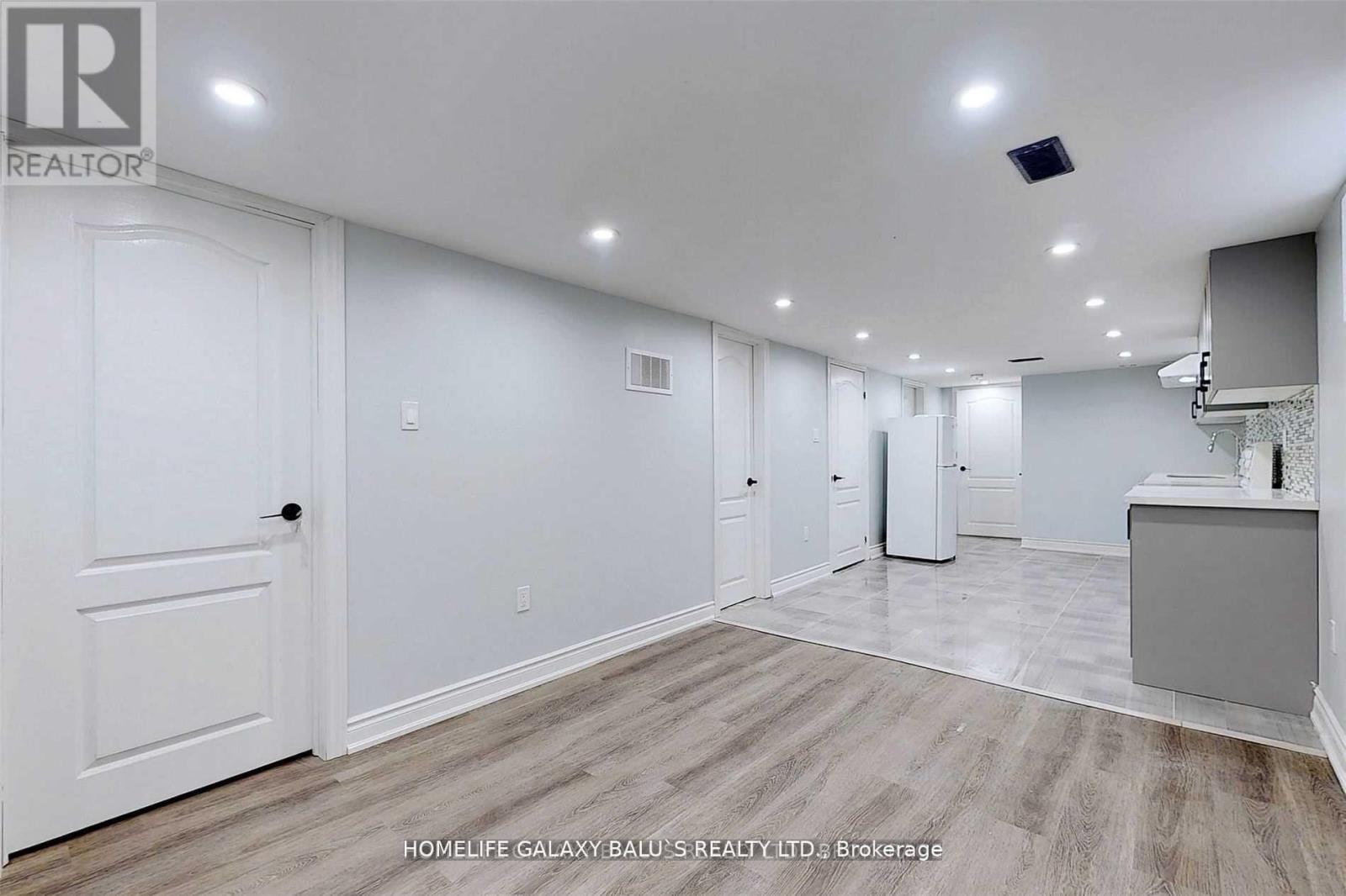 A spacious room with a white door and a white cabinet.