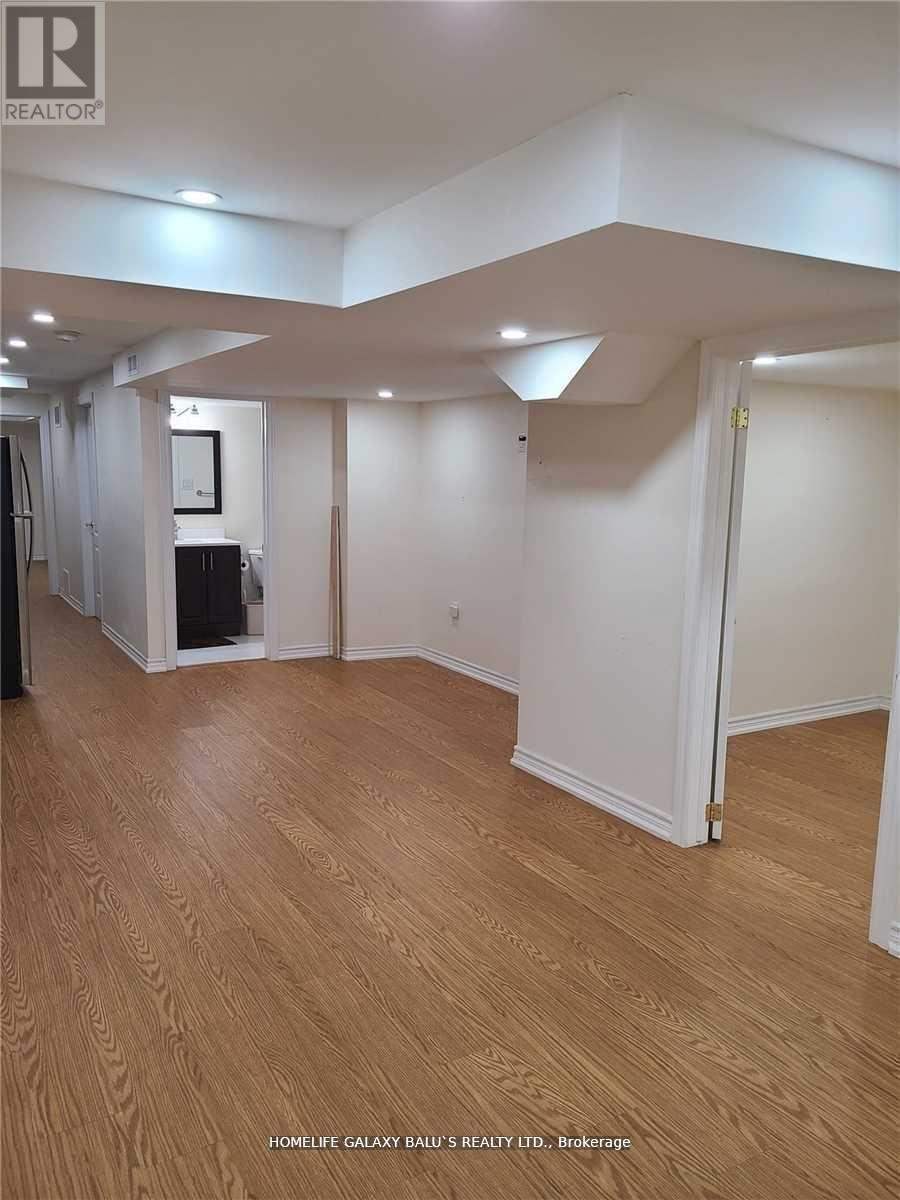A room with wooden flooring and white walls.