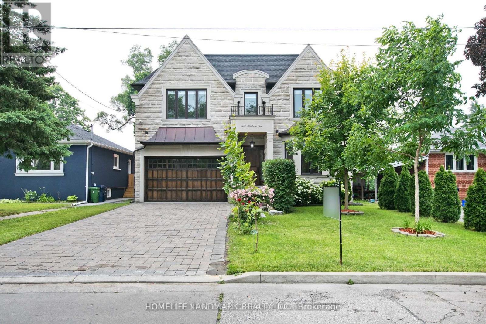 A large house with a brick driveway in front.
