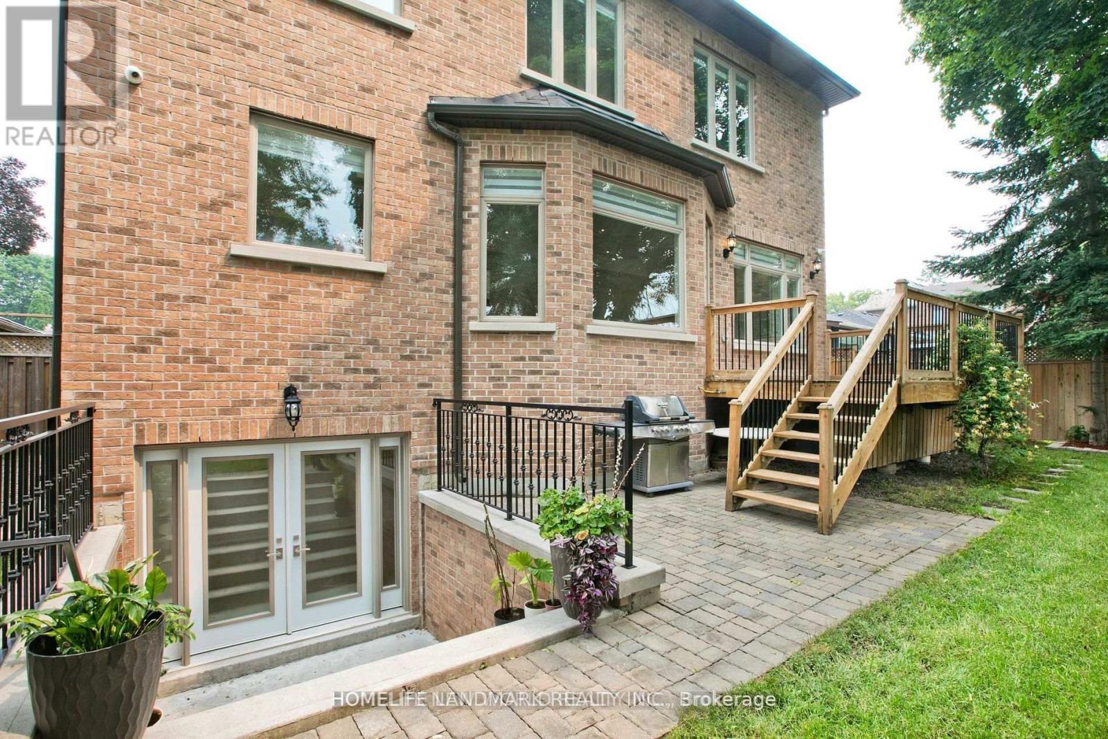 A brick house with a deck and a patio.