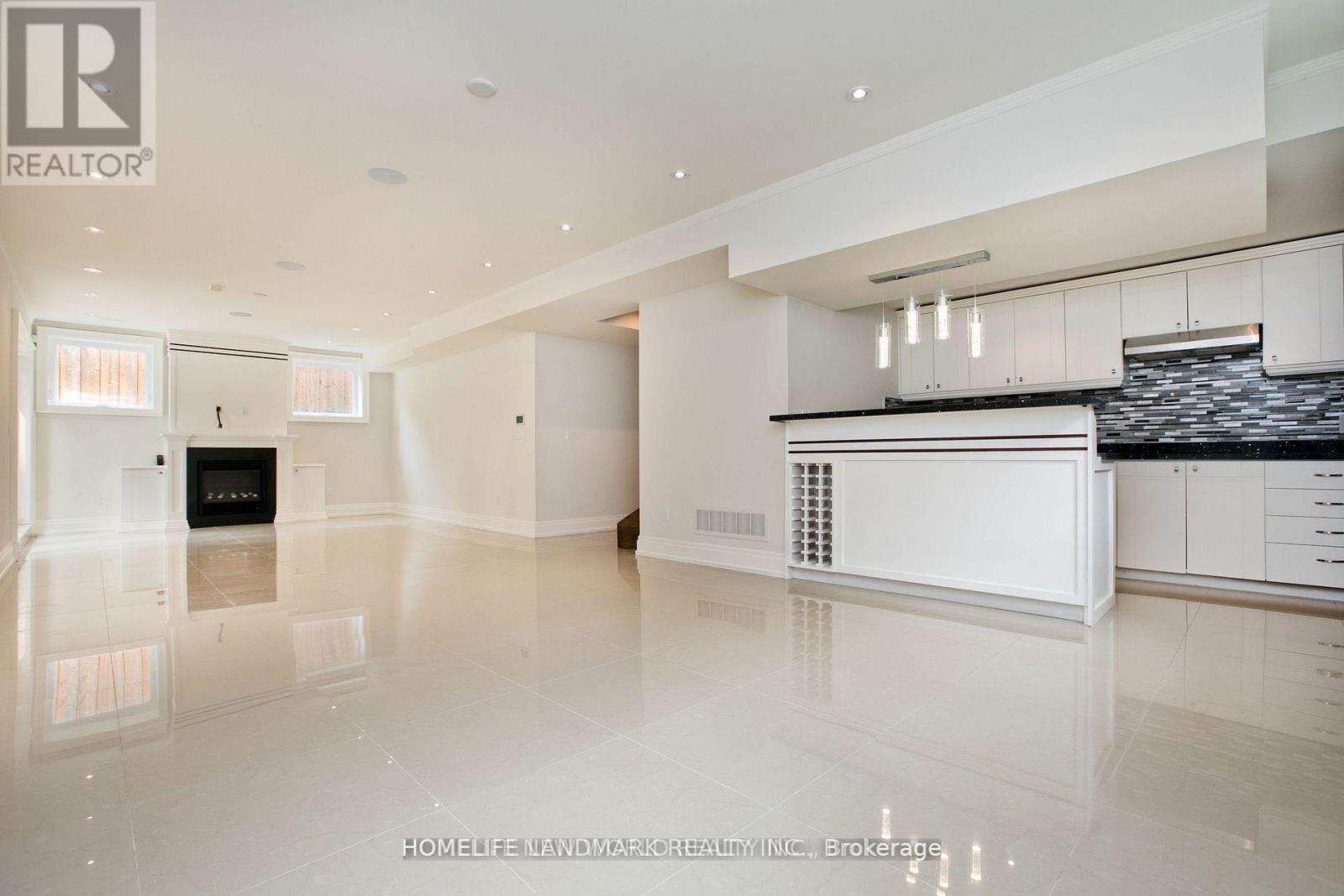 A spacious, well-lit kitchen with white cabinets and a black countertop.