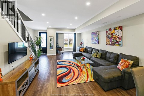 A living room with a black couch and a television.